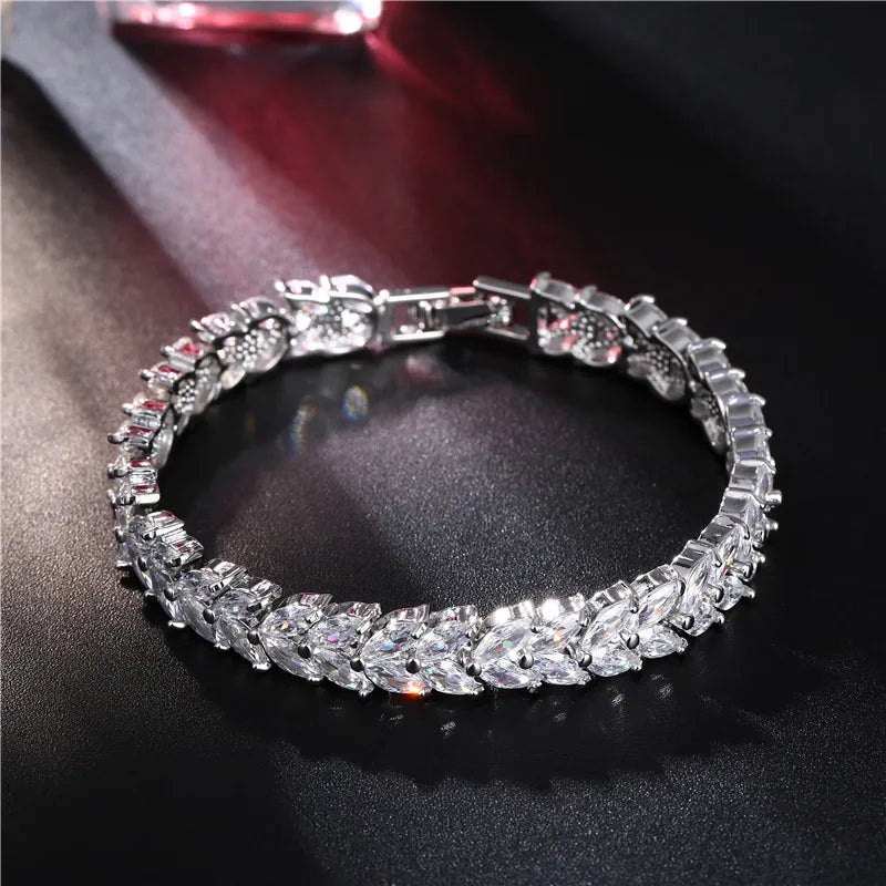 Silver bracelet with clear gemstones on a dark surface