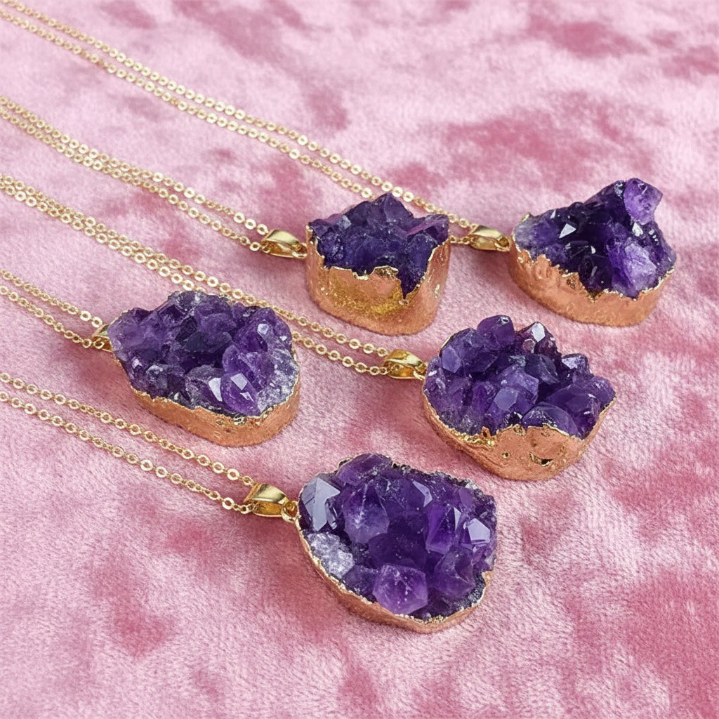 Purple crystal necklaces with gold accents on a dark surface