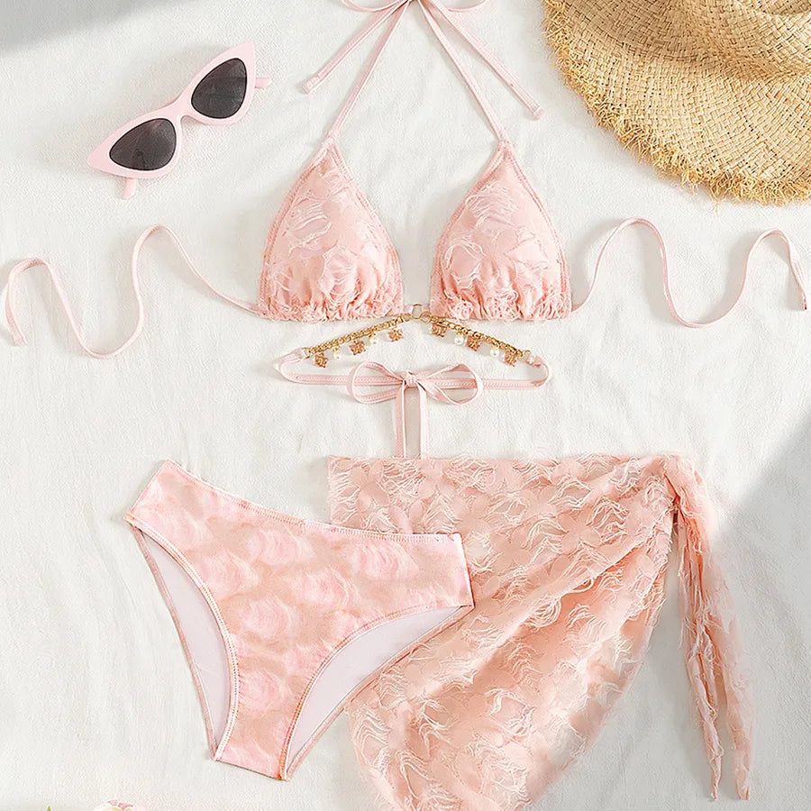 Pink bikini set with sunglasses and a hat on a light background