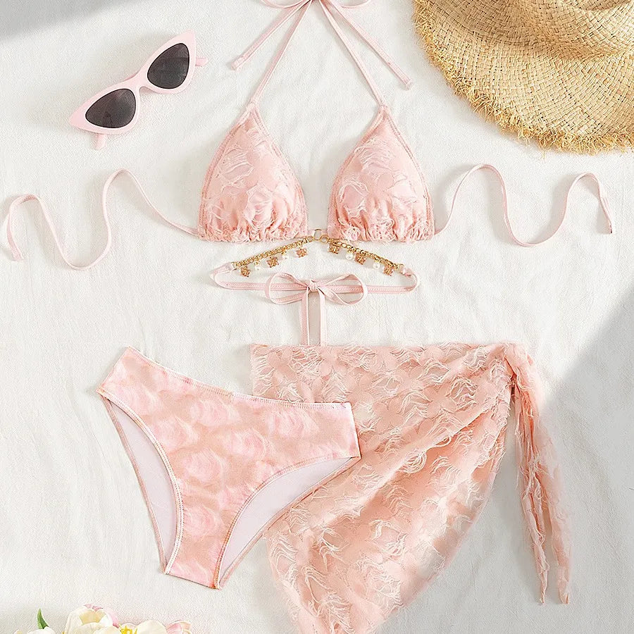 Pink bikini set with sunglasses and a hat on a light background