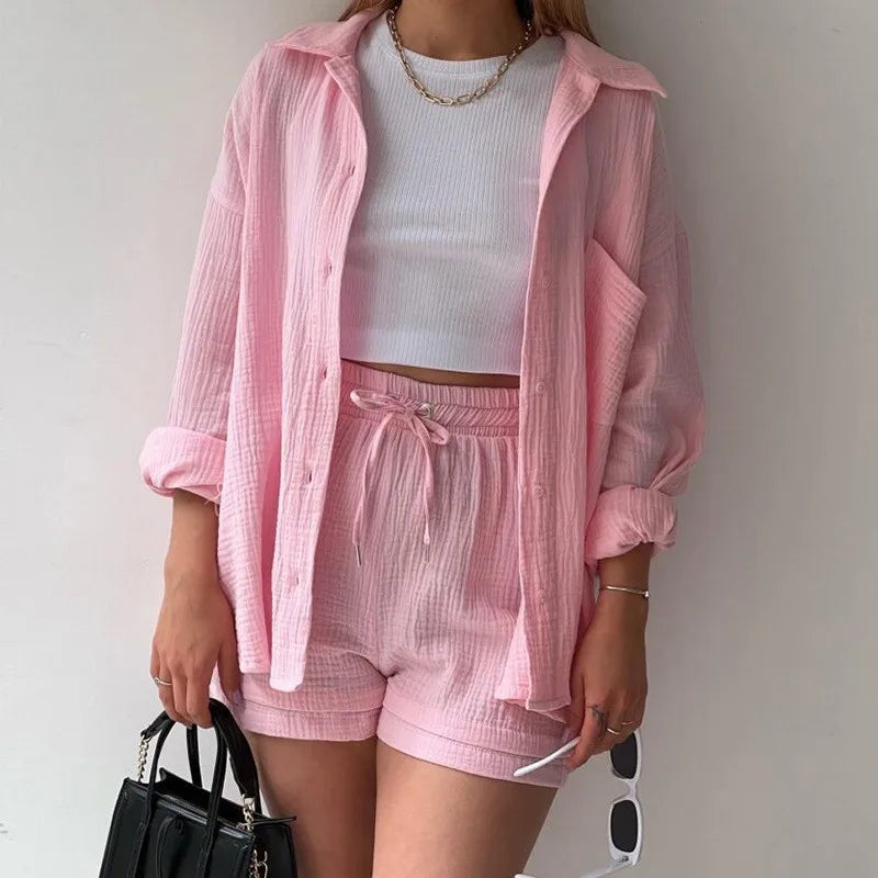 Person wearing a pink outfit with a white top against a plain background. Long sleeve pink shirt and pink shorts set.