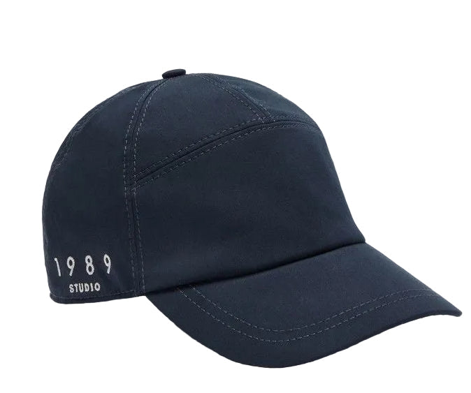 Navy blue cap with '1989 Studio' text on a light gray background