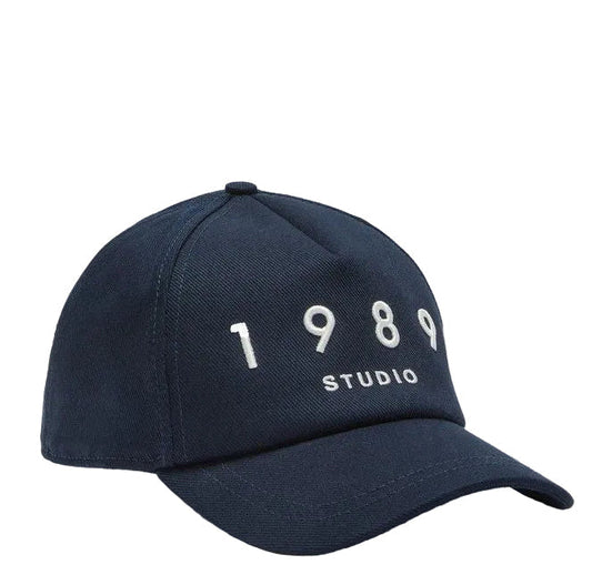 Navy blue cap with '1989 Studio' text on a light gray background