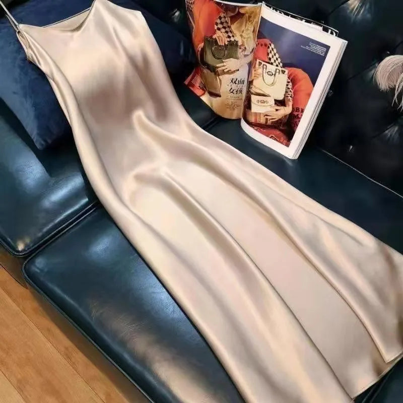 Beige slip dress on a black leather couch with a magazine underneath
