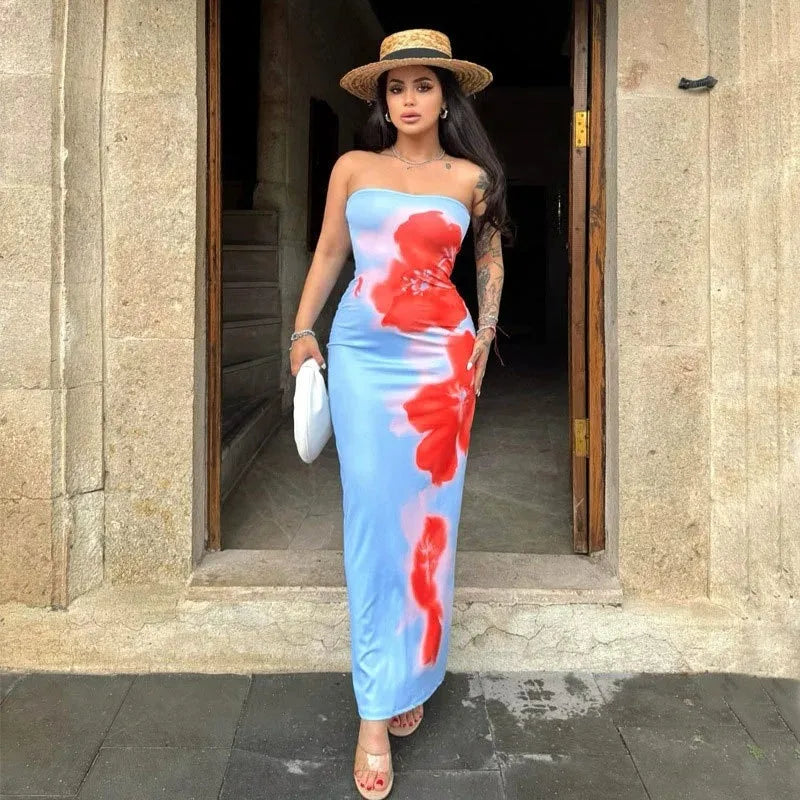 Woman in a strapless floral dress standing in front of a stone building entrance. Vacation resort dress 