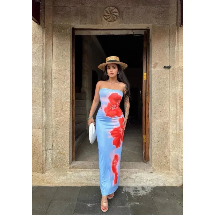 Woman in a floral dress standing in front of a stone building entrance. Vacation resort dress