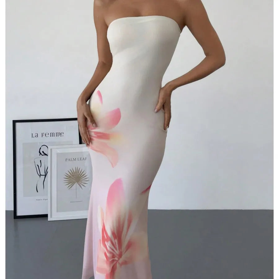 Woman wearing a strapless dress with floral design in a minimalistic setting. Vacation resort dress