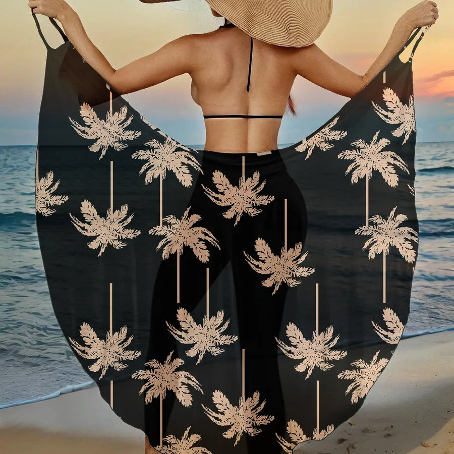 Woman on a beach with a black palm tree patterned cover-up