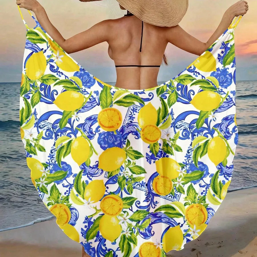 Person holding a beach towel with lemon pattern by the ocean