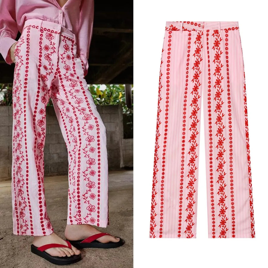 White pants with red floral patterns worn by a person, with a close-up of the pants on a white background. pink pants with red flowers