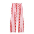 Pink pants with red floral embroidery on a white background pink pants with red flowers