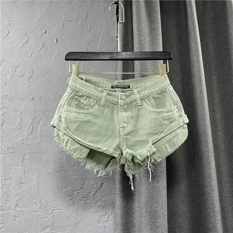 Mint green denim shorts on a hanger against a gray background
