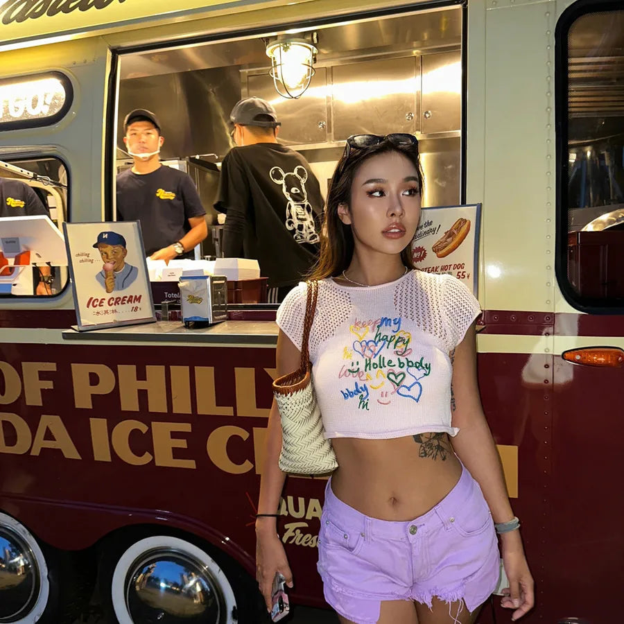 Woman standing in front of an ice cream truck with a person inside