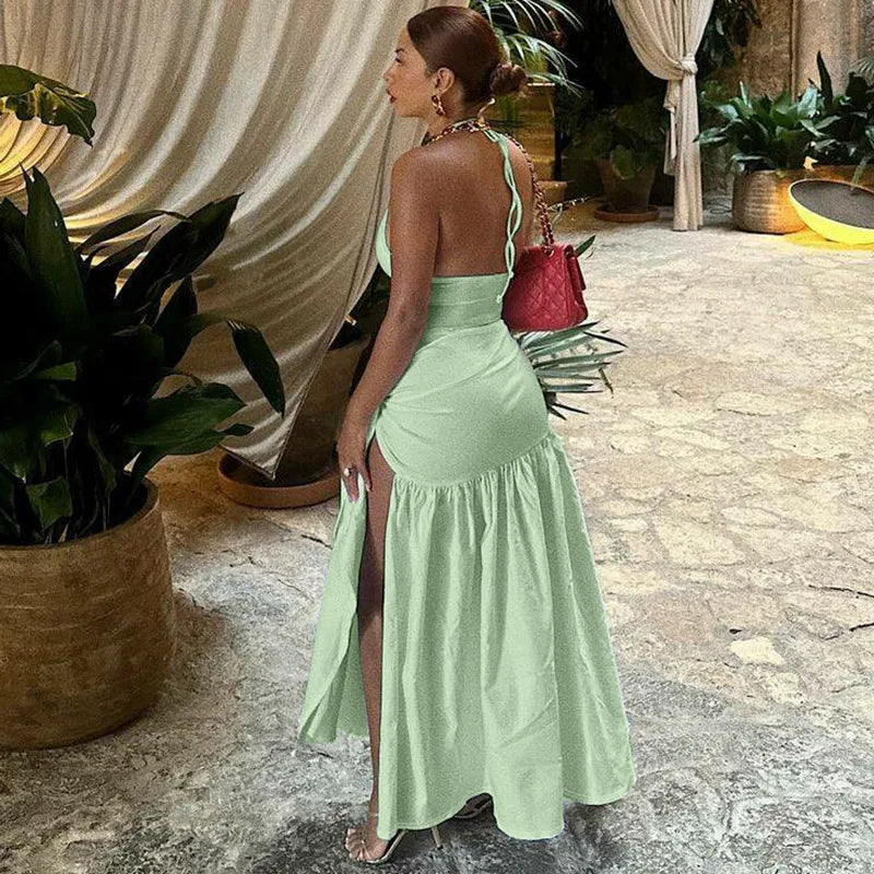 Woman in a light green dress standing in an outdoor setting with plants and draped fabric. halter skirt set, two piece outfit women, skirt co ord set, matching set women, bodycon skirt set, sexy vacation outfit, halter neck outfit, asymmetrical outfit, date night outfit, clubwear women, birthday outfit women, resort wear women, vacation clothes women, slim fit skirt set, elegant two piece set, womens co ord set, sexy matching set, summer outfit women, luxury fashion women, trendy two piece outfit swimsuit