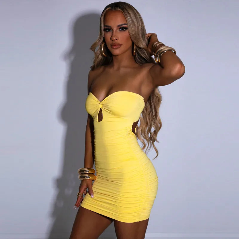 Woman wearing a yellow strapless dress against a plain background