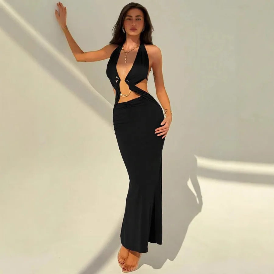 Woman wearing a black dress with cut-out design against a plain background