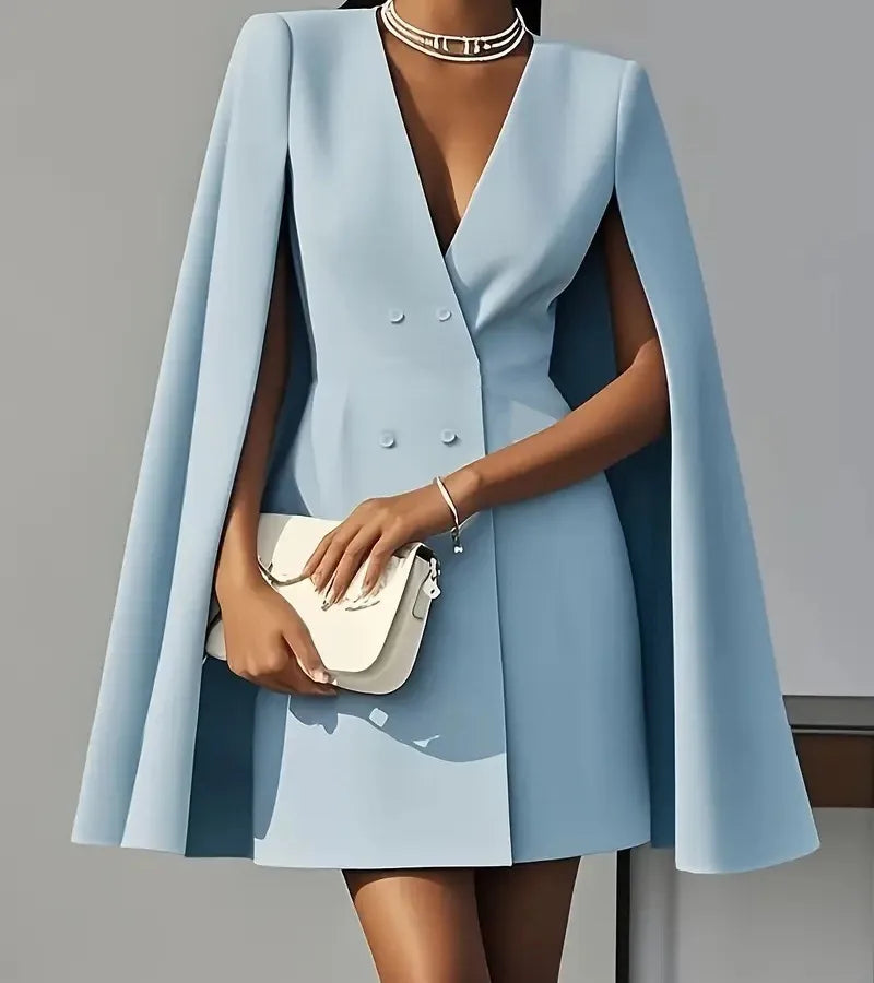 Light blue cape dress worn by a model against a gray background powder blue blazer coat dress