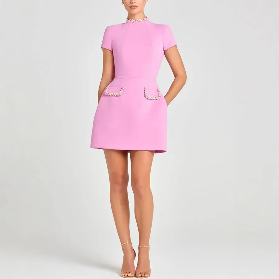 Pink dress with pearl details on a white background
