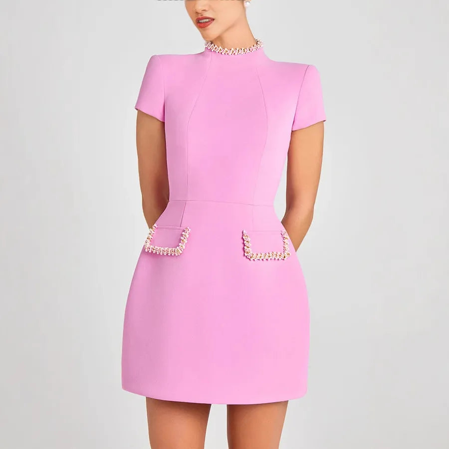 Pink dress with pearl embellishments on a plain background