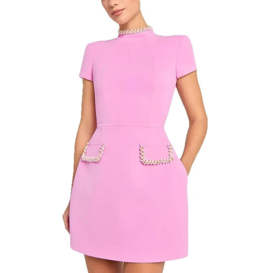 Pink dress with pearl embellishments on a white background