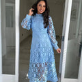Woman wearing a blue lace dress standing in a doorway.