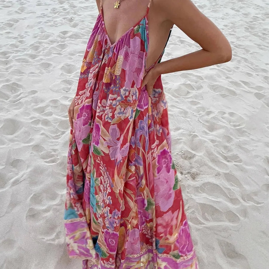 Person wearing a colorful floral dress on a sandy beach