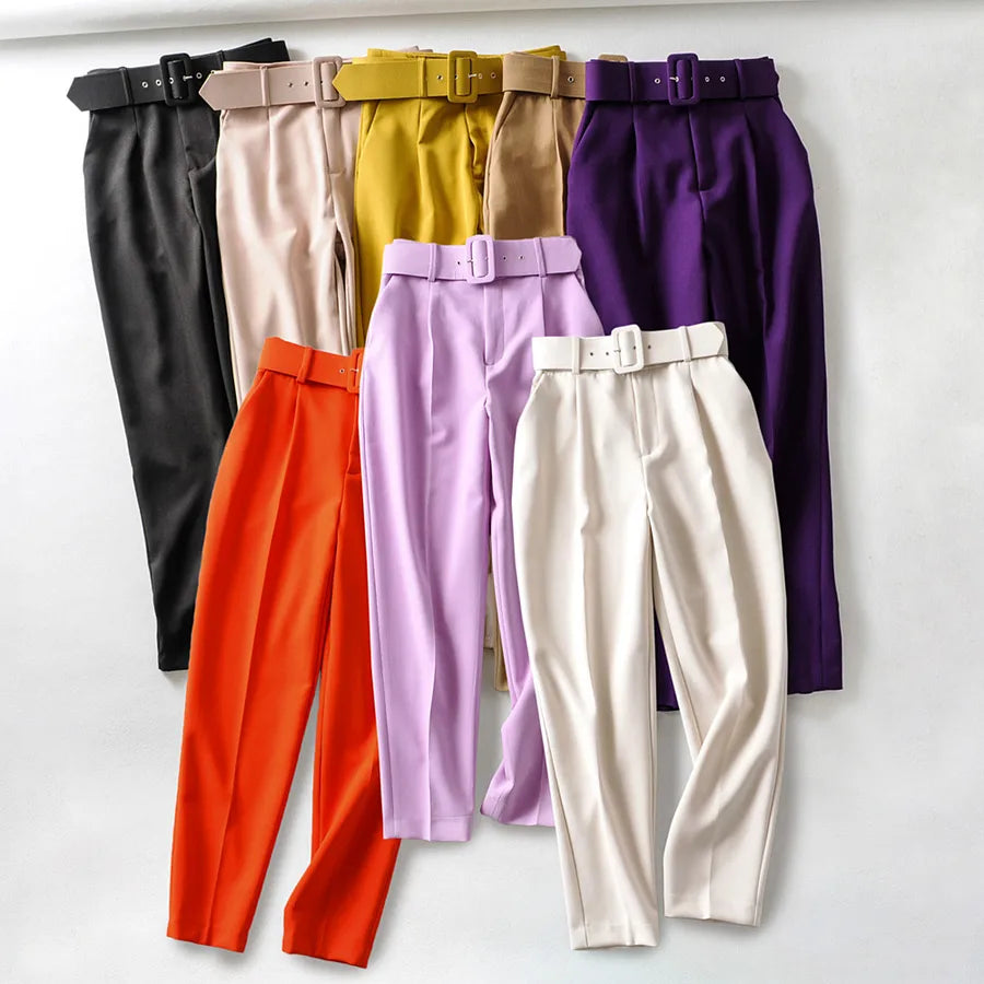 Set of colorful pants with belts on a white background