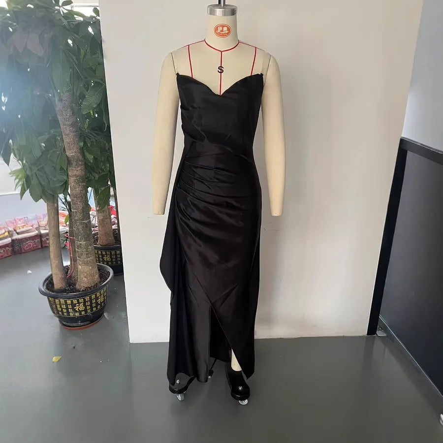 Black evening gown on a mannequin against a plain background