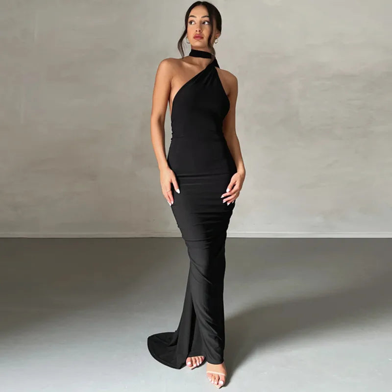 Woman wearing a black one-shoulder dress against a plain background