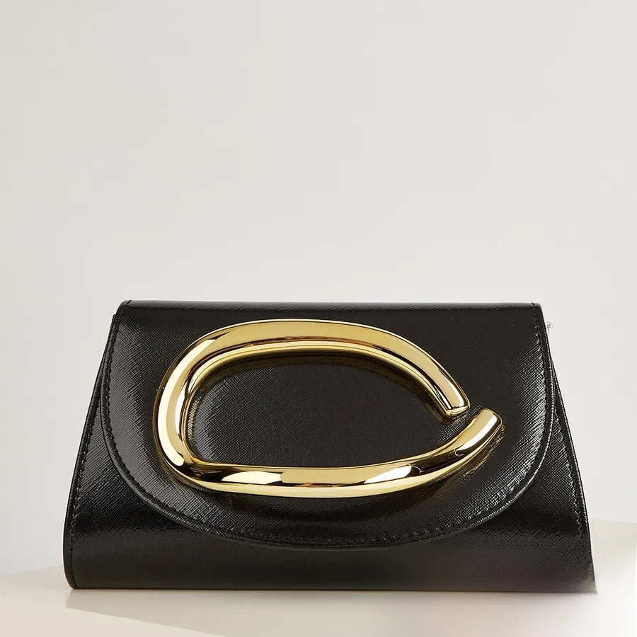 Black handbag with a gold handle on a light gray background