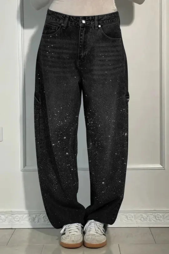 Black jeans with white speckles worn by a person on a light gray background rhinestone jeans women, sparkly jeans, crystal jeans, bling denim pants, embellished jeans, high waisted jeans women, star jeans, rhinestone denim, designer inspired jeans, glam jeans, streetwear jeans women, trendy denim pants, fashion jeans women, statement jeans, luxury denim, straight leg jeans, commuter style fashion, women's denim pants, sparkle jeans, casual glam outfit