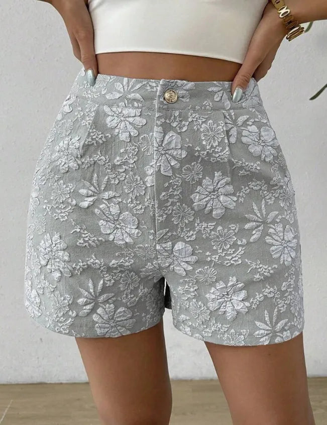 Gray floral shorts worn by a person against a neutral background high waisted shorts women, jacquard shorts, vintage shorts women, boho shorts, summer shorts women, boutique shorts, woven shorts women, resort wear women, vacation outfit women, chic summer shorts, elegant shorts women, festival outfit women, high rise shorts, trendy summer fashion, casual chic outfit, bohemian shorts, statement shorts women, women's fashion shorts, luxury summer style, boutique clothing women