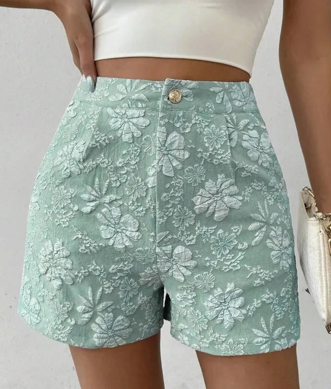 Green floral shorts worn by a person on a plain background high waisted shorts women, jacquard shorts, vintage shorts women, boho shorts, summer shorts women, boutique shorts, woven shorts women, resort wear women, vacation outfit women, chic summer shorts, elegant shorts women, festival outfit women, high rise shorts, trendy summer fashion, casual chic outfit, bohemian shorts, statement shorts women, women's fashion shorts, luxury summer style, boutique clothing women