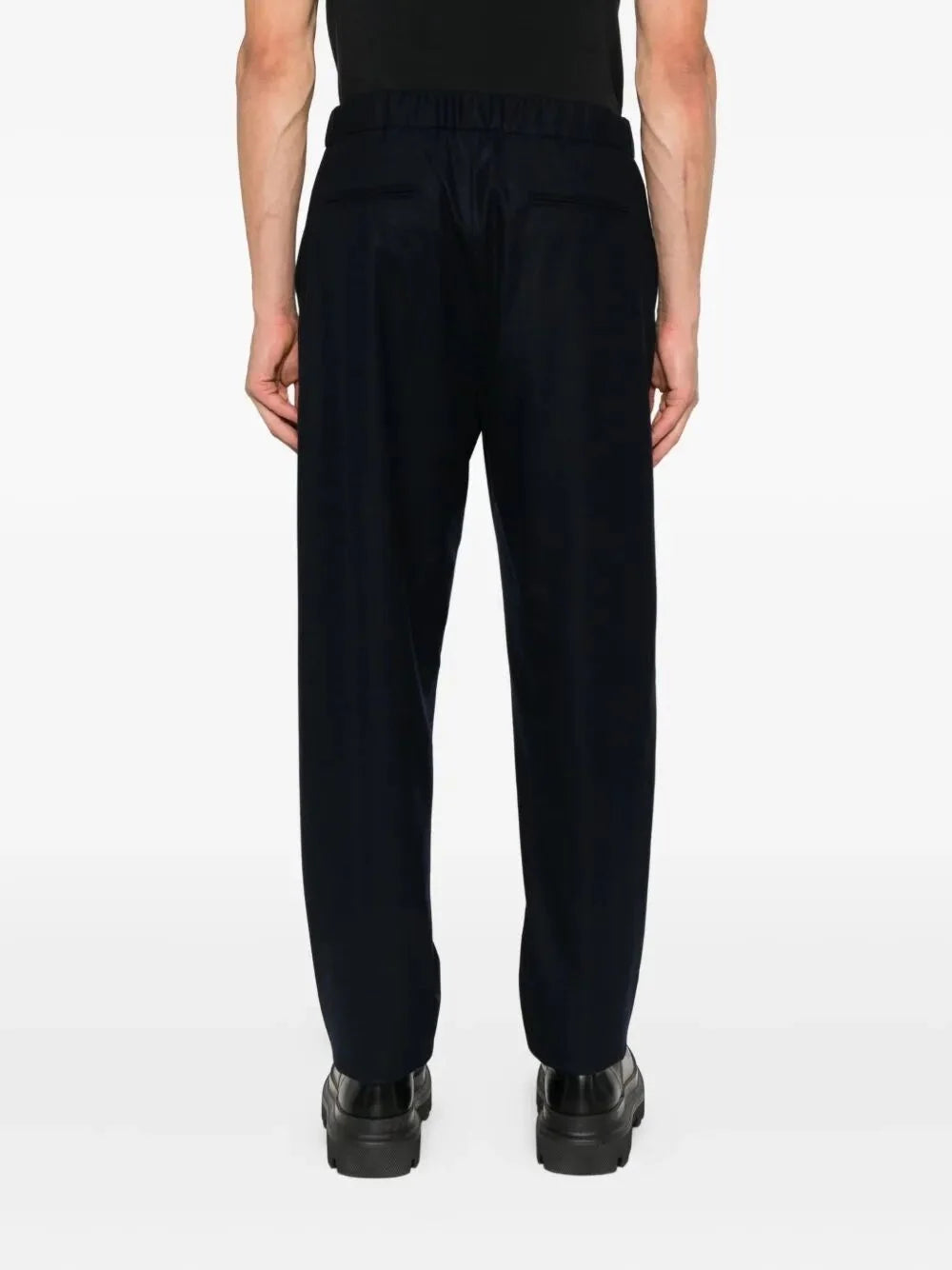 Person wearing black pants on a white background