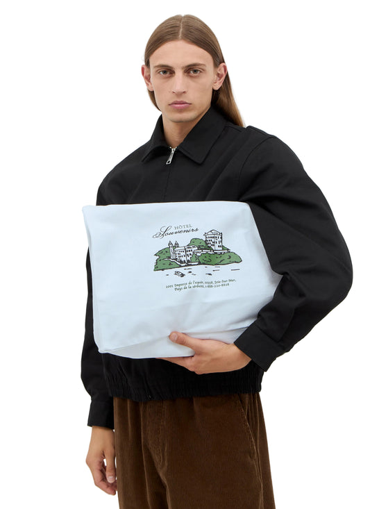 Person holding a tote bag with a design on a plain background