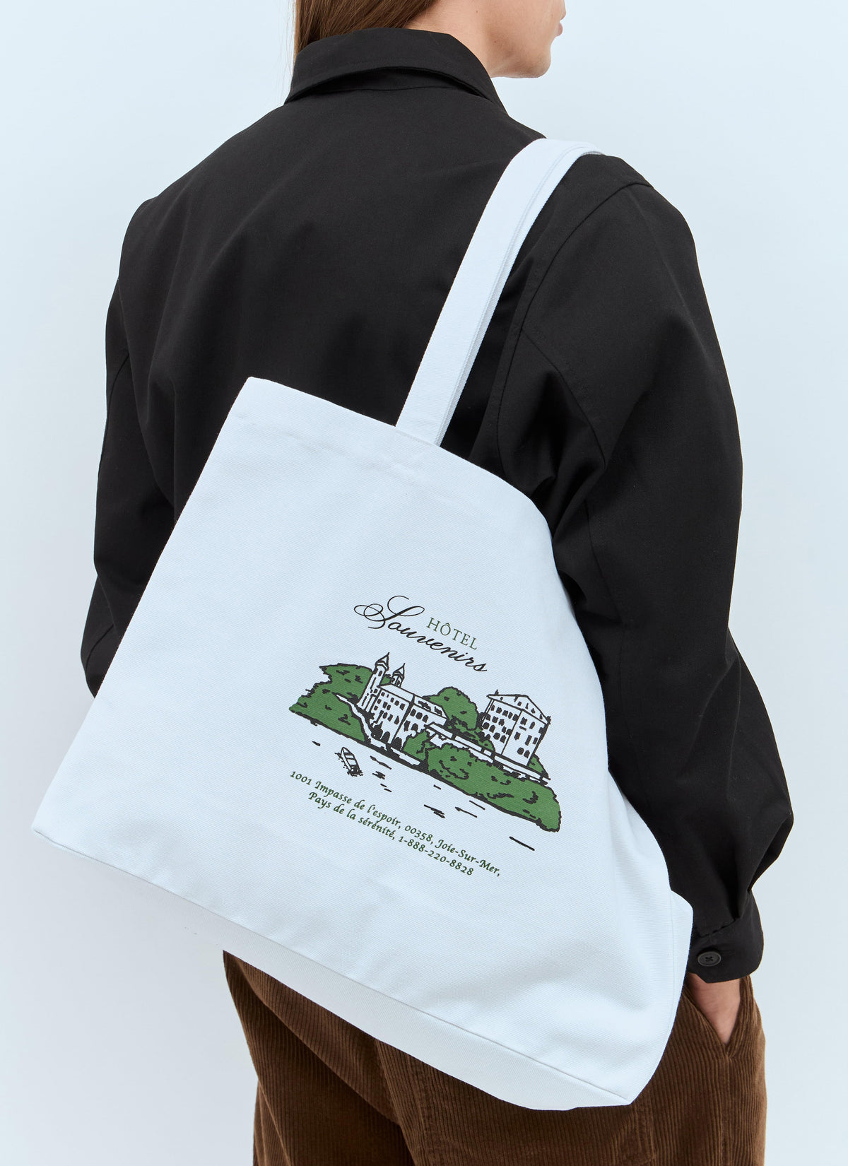 Person wearing a tote bag with a green graphic design on a white background