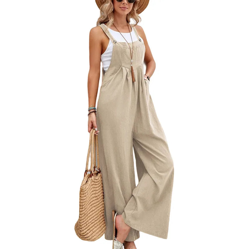 Woman wearing a beige jumpsuit holding a straw bag on a white background
