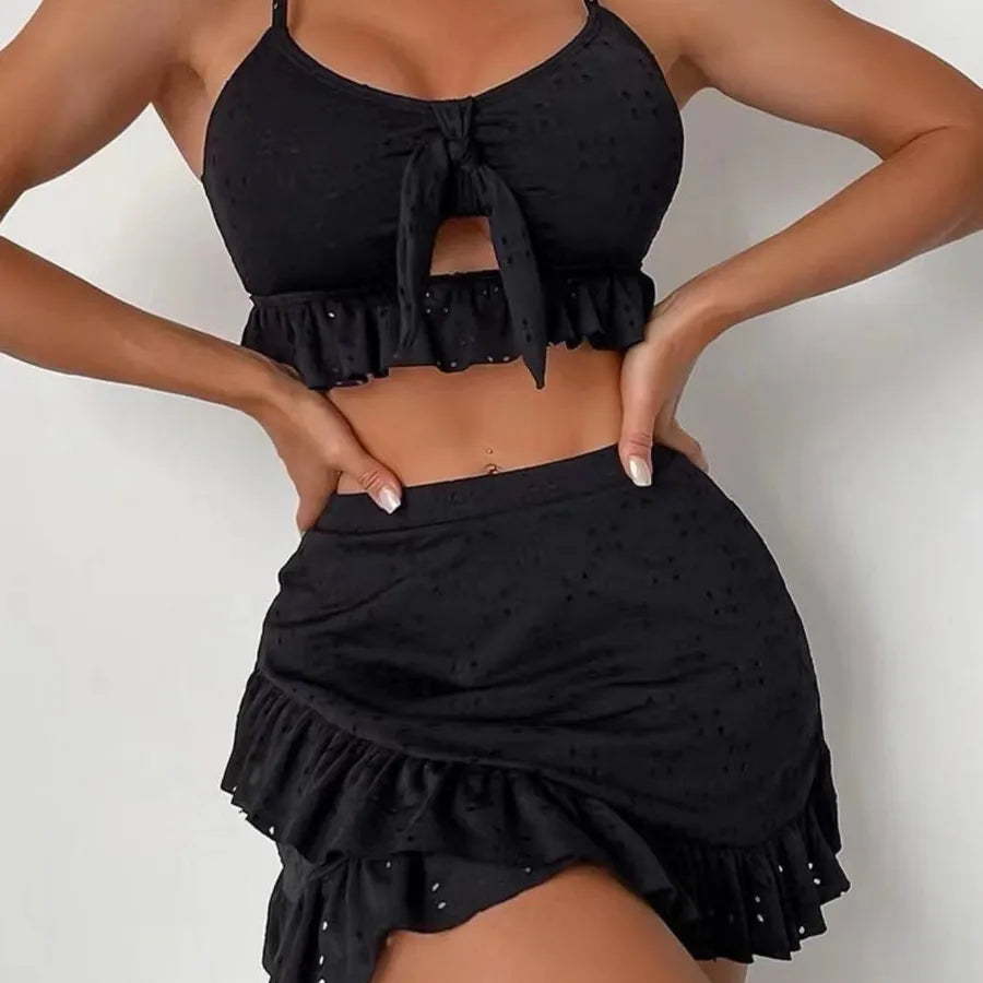 Black ruffled top and skirt set on a plain background