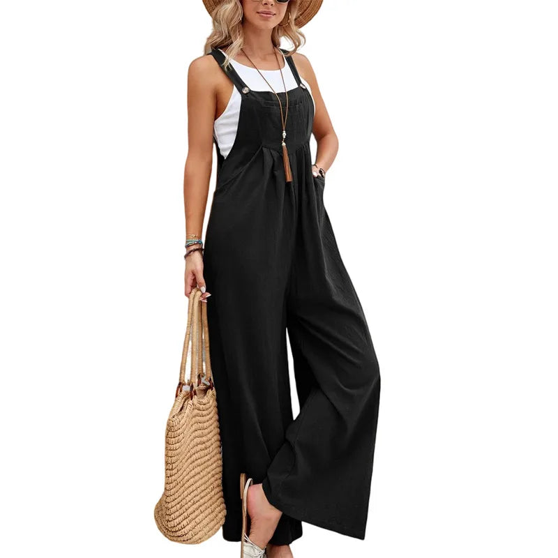 Woman wearing a black jumpsuit with a white top, holding a straw bag on a white background