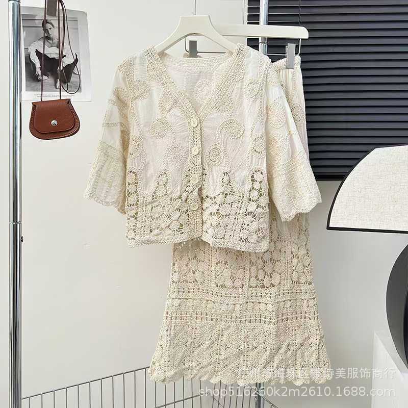 Lace outfit on a hanger against a white wall with a purse and photo in the background.