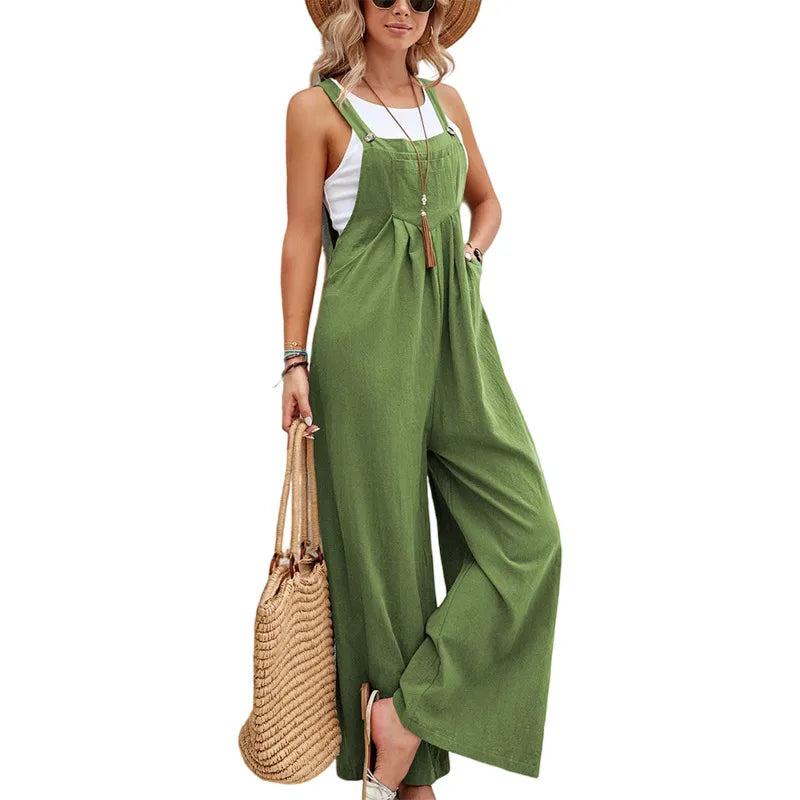 Woman wearing a green jumpsuit holding a straw bag on a white background