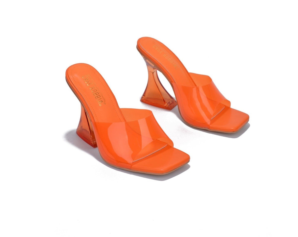 Pair of orange high-heeled shoes on a white background