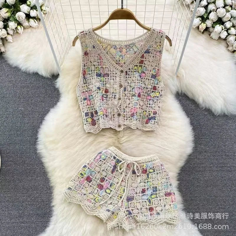 Colorful crochet top and shorts set on a white fur surface with floral decorations.