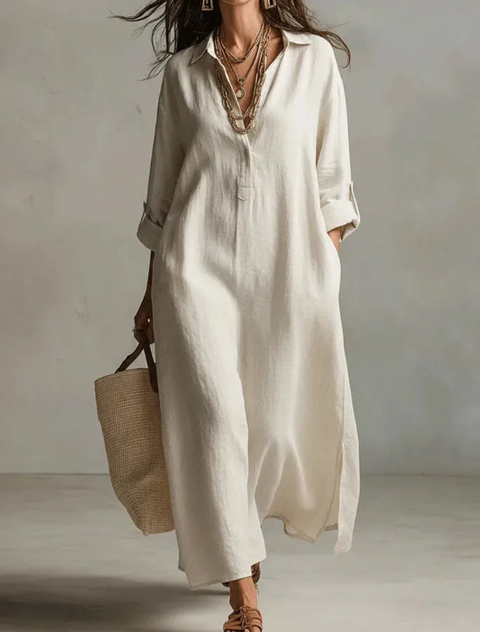 Person wearing a long beige dress holding a straw bag against a plain background