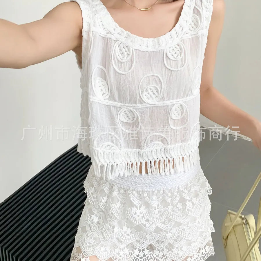 White lace sleeveless top worn by a person against a neutral background