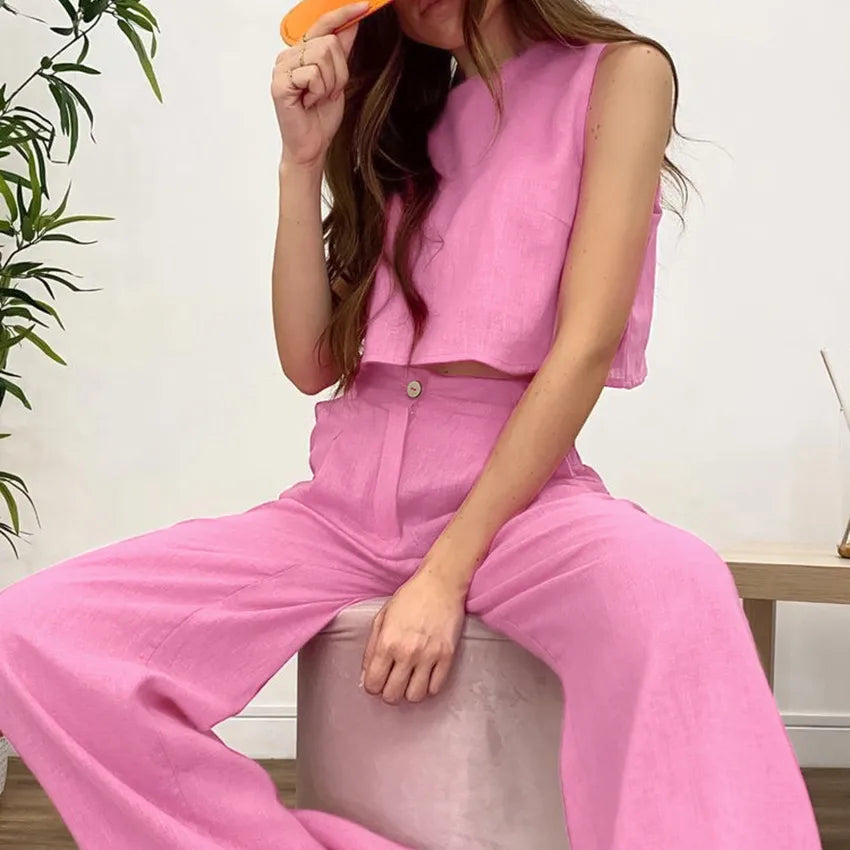 Person wearing a pink outfit sitting on a chair indoors.
