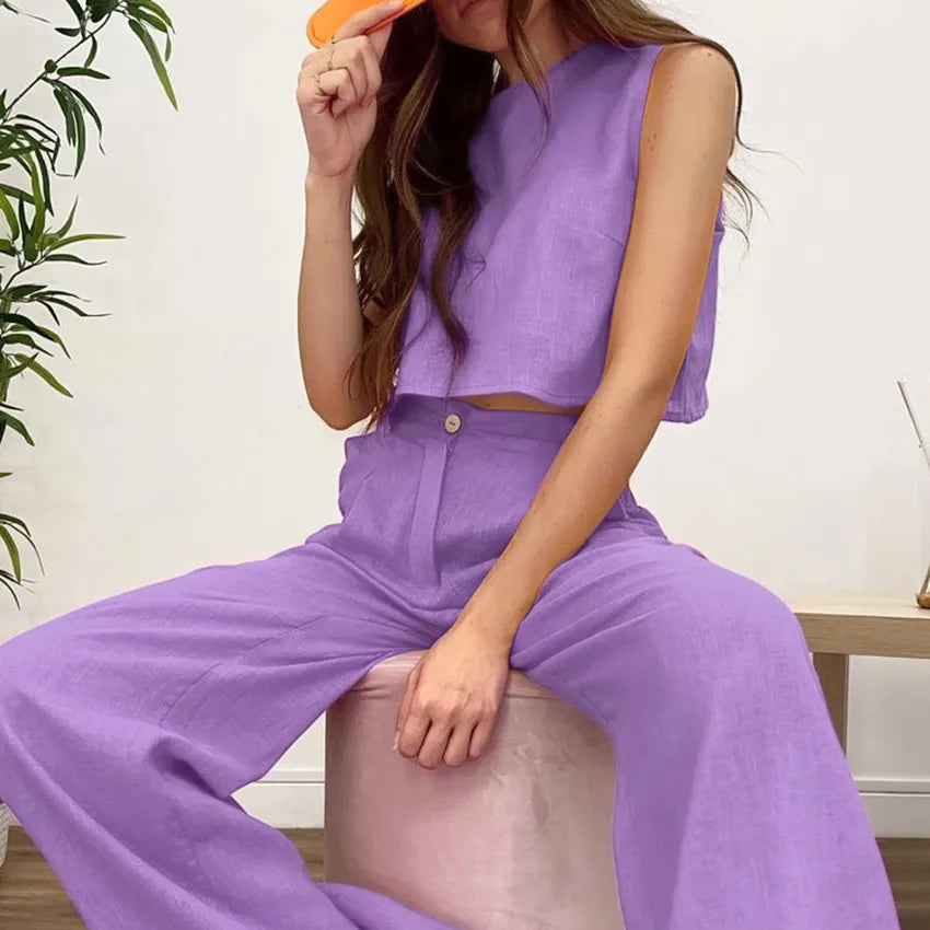 Woman wearing a purple outfit sitting on a chair indoors.
