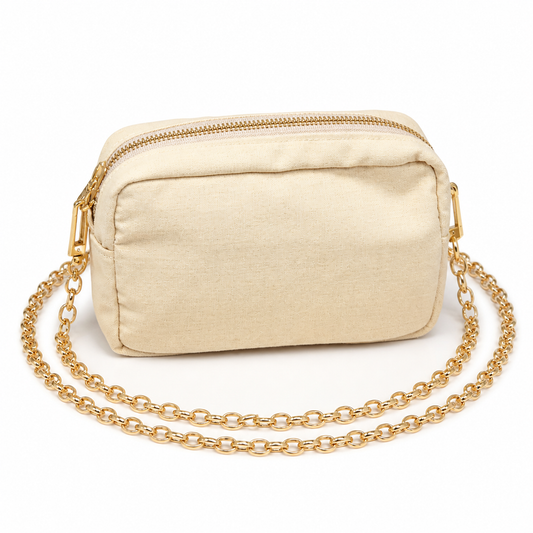 A small beige canvas crossbody bag with a gold-tone chain strap and a top zipper, shown on a plain white background.