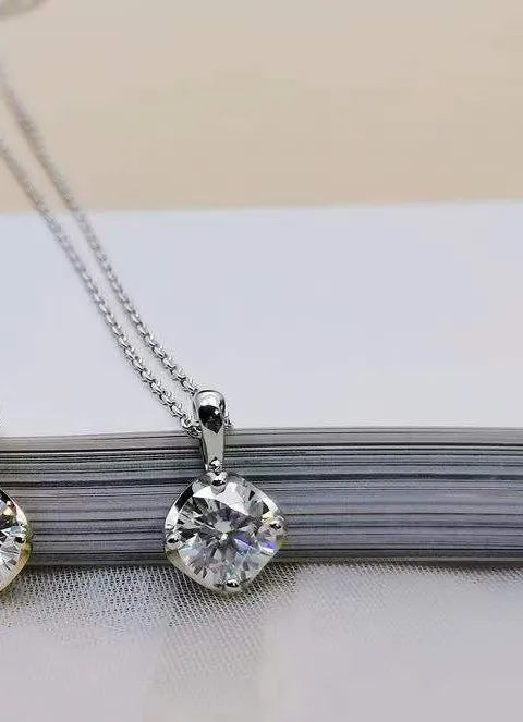 Silver necklace with a round diamond pendant on a white surface