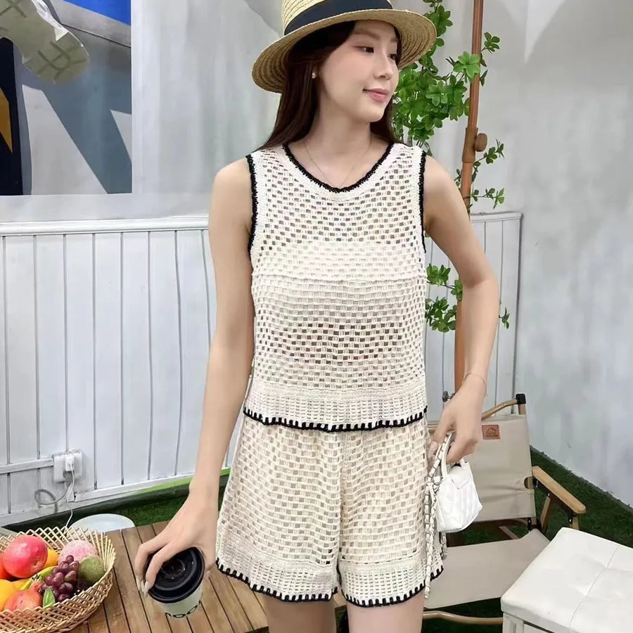 Woman in a white crochet outfit holding a coffee cup outdoors.